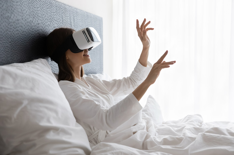 Person in a hotel bed with VR headset on