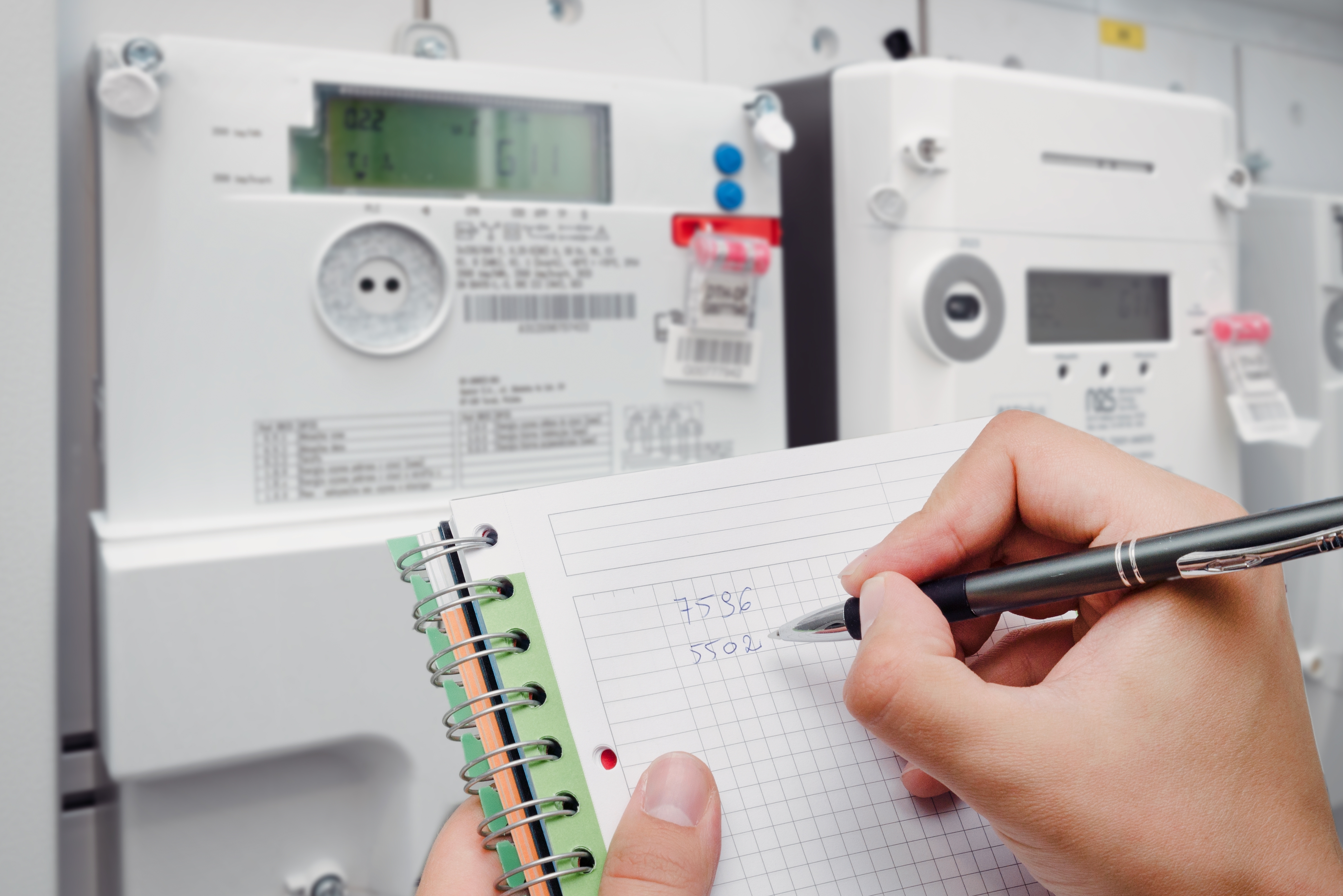 Person writing measurements on paper